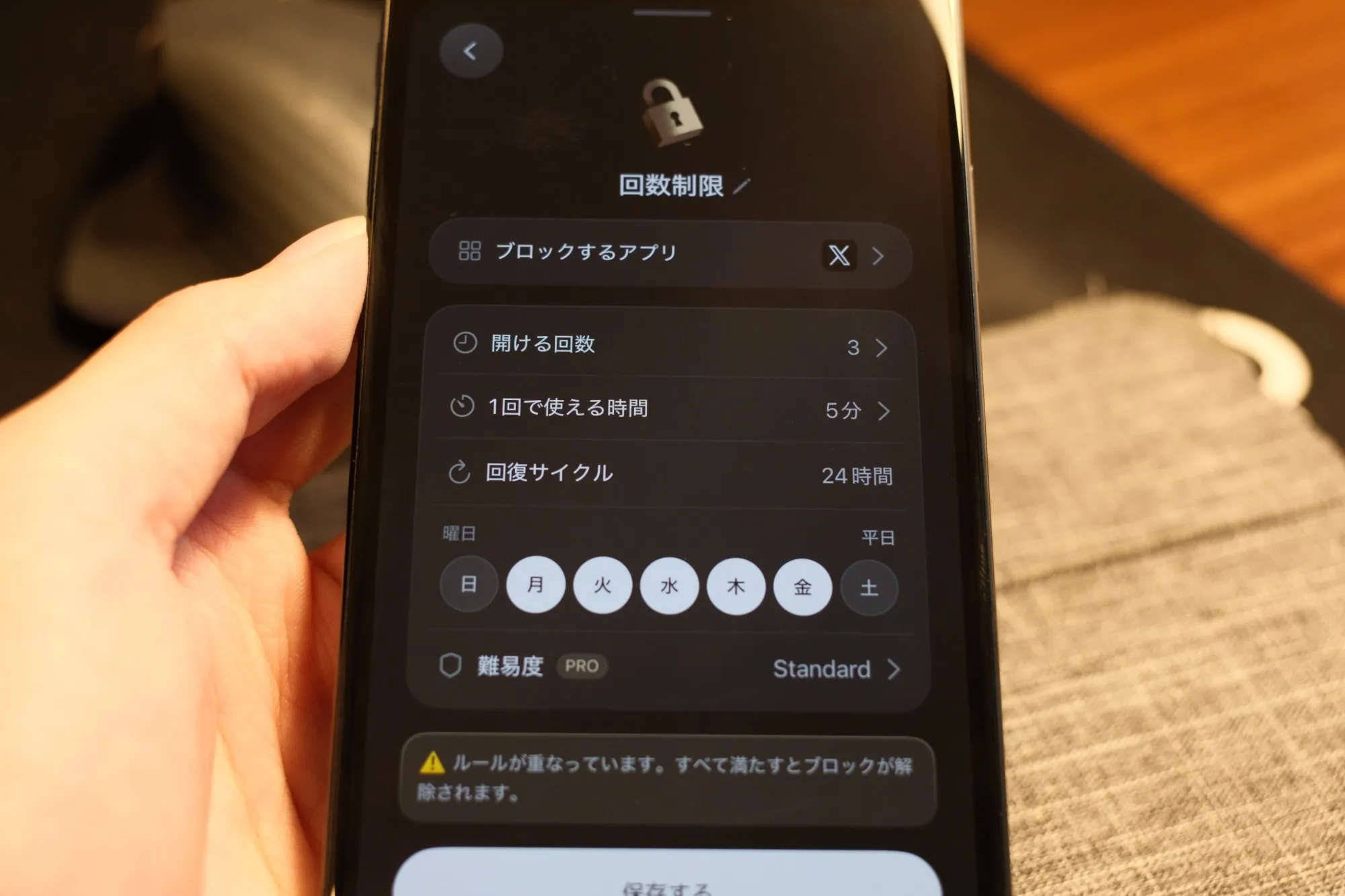 スマホに表示された、回数制限のルールを作る画面の写真。ブロックするアプリに X が選ばれ、開ける回数は3、1回で使える時間は5分、曜日は月曜から金曜の平日が選ばれている
