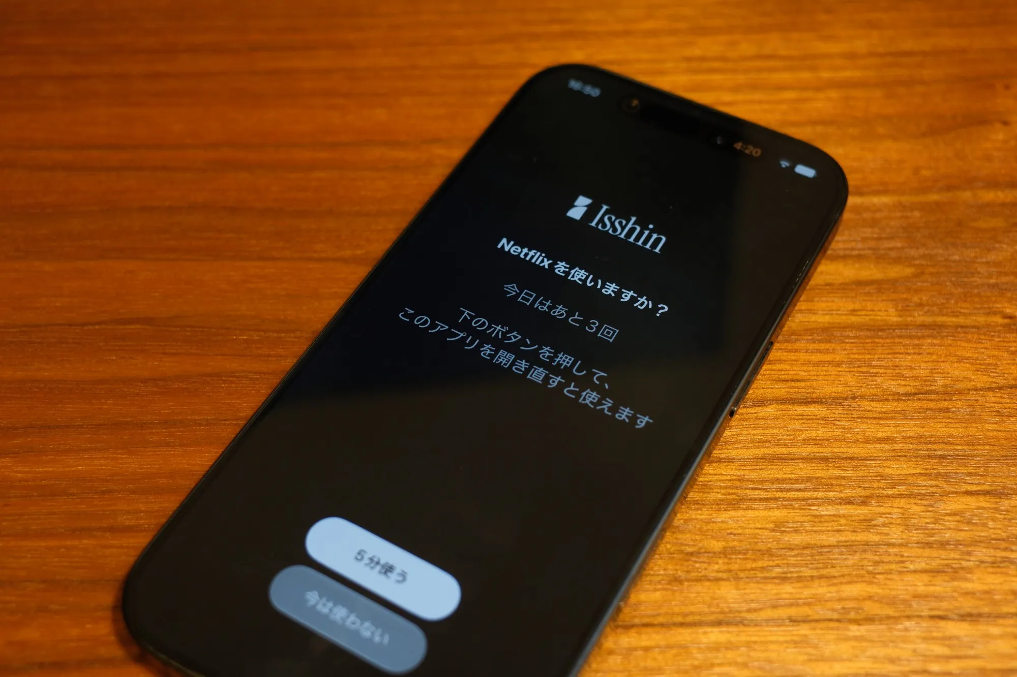 スマホに表示されたブロック画面の写真。「Netflixを使いますか？」「今日はあと3回」「下のボタンを押して、このアプリを開き直すと使えます」と表示され、「5分使う」と「今は使わない」のボタンが並んでいる